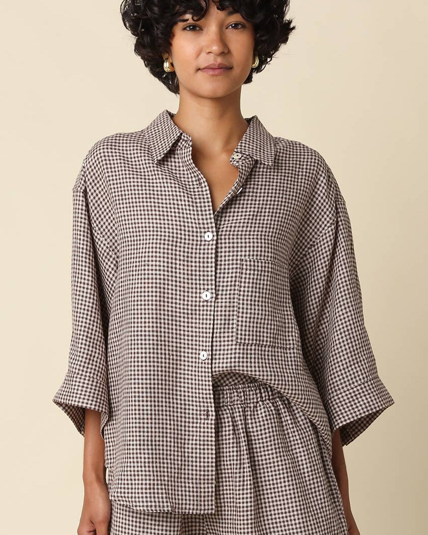 Woman wearing a checkered outfit on a beige background