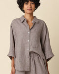 Woman wearing a checkered outfit on a beige background
