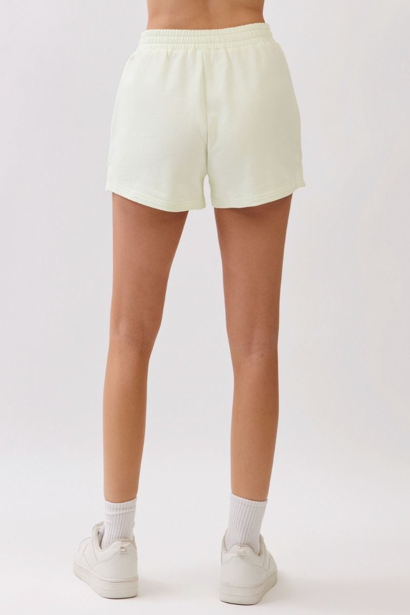 Person wearing light-colored shorts on a plain background