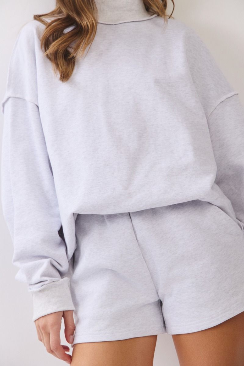 Light gray sweatshirt and shorts set on a plain background