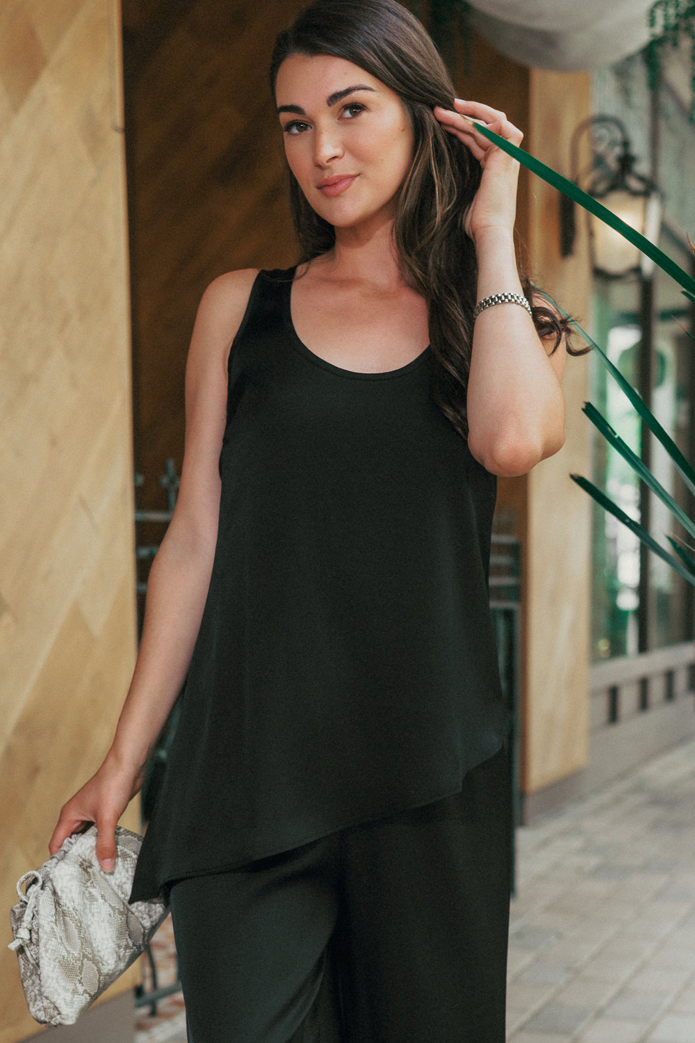 A versatile black tank top for women featuring a draped silhouette, perfect for everyday wear, travel, or elevated casual styling.